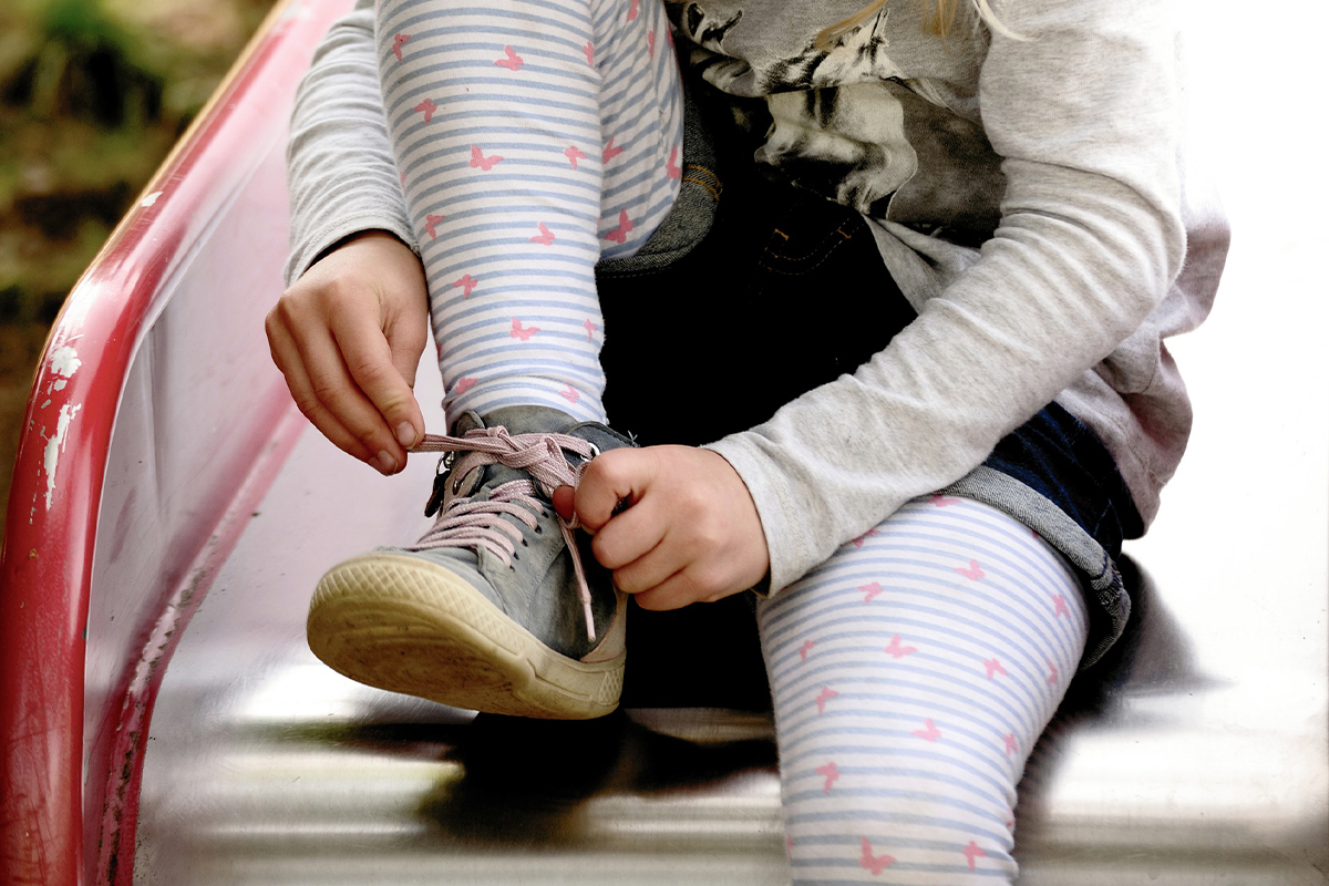 Kind bindet Schuhe
