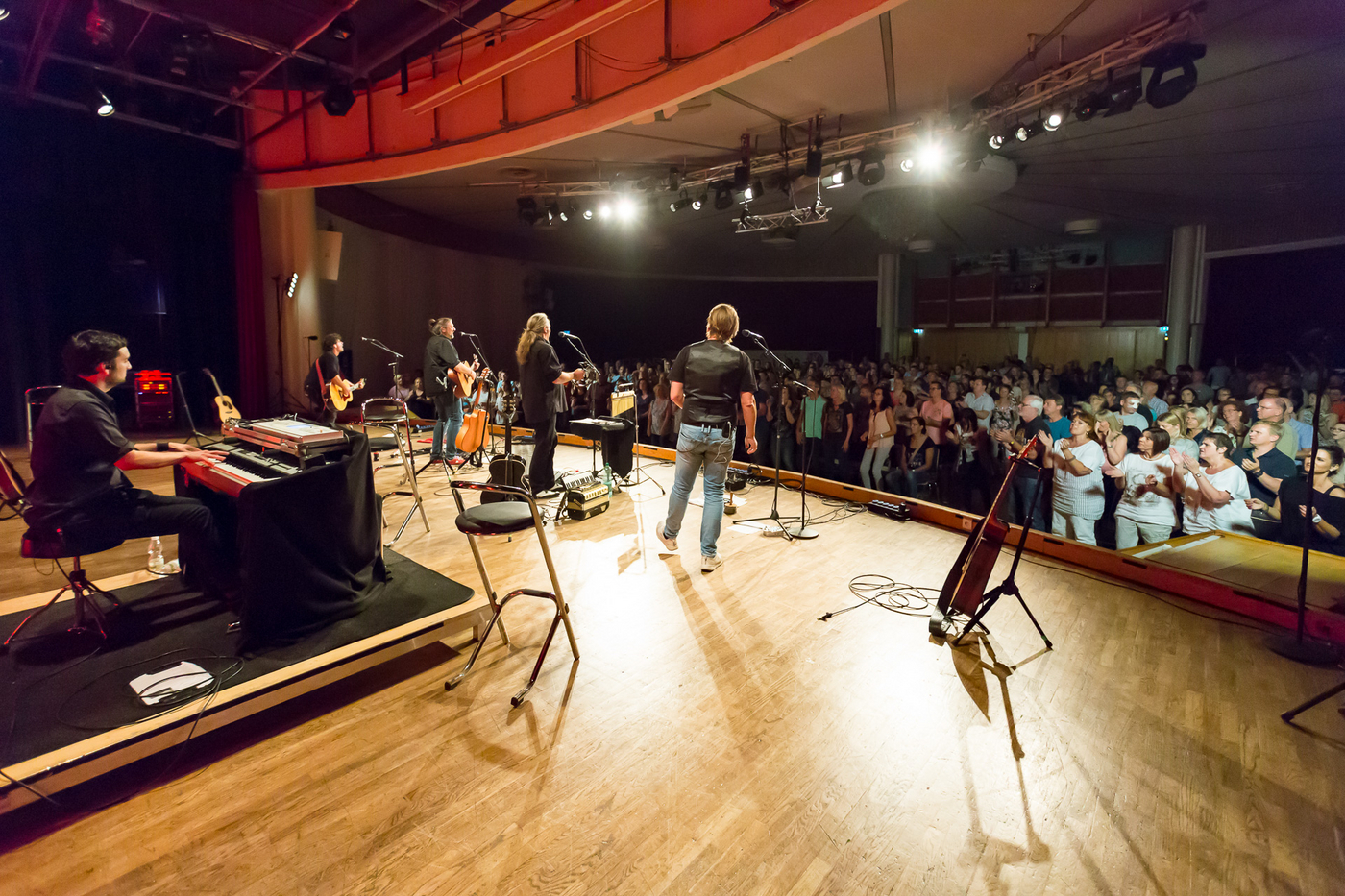 Bühne der Kürnberghalle mit Holzboden und drei Musikern