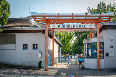 Eingang Kürnbergbad mit oranger Glasüberdachung