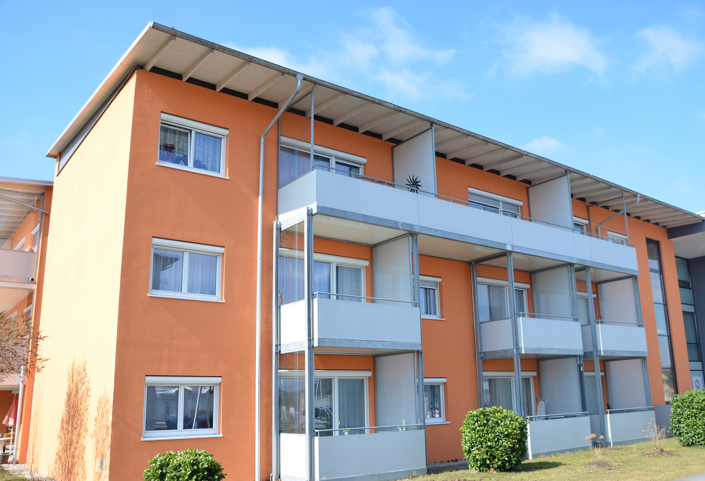 Oranger Wohnblock mit weißen Balkonen
