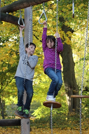 ein Junge und ein Mädchen die auf Seilen klettern