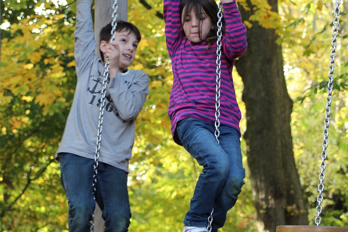 ein Junge und ein Mädchen die auf Seilen klettern